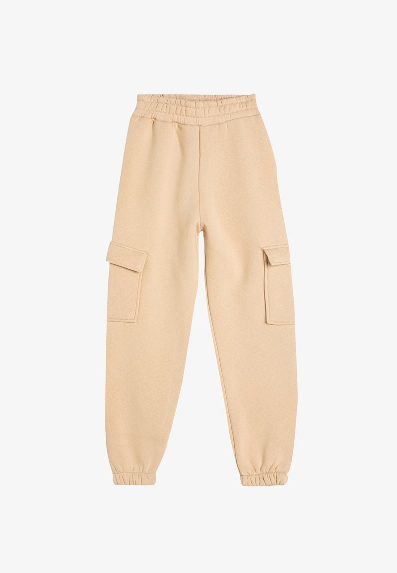 Beige joggingbroek met een zachte textuur, een elastische tailleband en twee zijvakjes. Boordjes bij de enkels zorgen voor een getailleerde pasvorm.