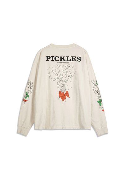 Dugih rukava kremasta košulja s crnim tekstom "PICKLES", grafikom ruke koja drži lisnate crvene rotkvice na leđima te odgovarajućim ilustracijama povrća na rukavima.