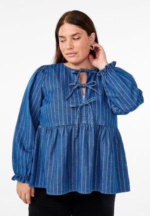 Blusa in denim blu con righe verticali bianche. Presenta un'apertura a chiave con lacci, maniche lunghe a palloncino e un orlo inferiore arricciato.