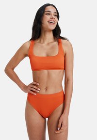 Set de bikini cu dungi portocalii, format dintr-un top cu decolteu pătrat și bretele late, alături de slipuri cu talie înaltă. Textură netedă și elastică.
