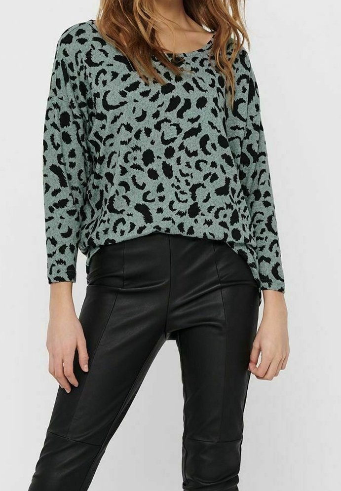 Mintgrüner Leopardenmuster-Pullover mit lockerer Passform und langen Ärmeln, kombiniert mit schwarzen Kunstlederhosen. Glattes Material, lässiges Design.