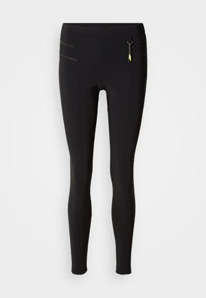 Zwarte legging gemaakt van elastisch materiaal, met een hoge taille, ritszakken met gele accenten en een soepele textuur.