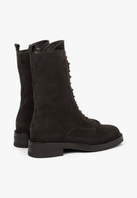 Brązowe zamszowe botki za kostkę na sznurówki z wytrzymałym słupkowym obcasem, charakteryzujące się gładką fakturą i pionowym szwem wzdłuż boków.