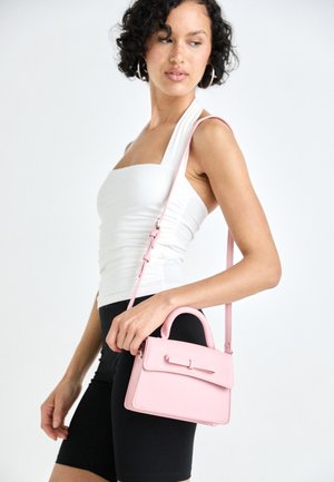 Mala zaobljena ružičasta od kože, pravokutnog oblika, s gornjom drškom i odvojivim remenom za preko ramena s detaljem mašnice.