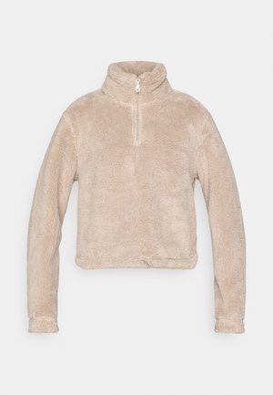 Beige fleecetrui met een hoge kraag en halve rits. Heeft lange mouwen en een korte zoom. Zachte, gestructureerde stof.