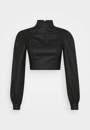 Veste noire courte avec manches longues bouffantes, col montant et texture lisse. Caractérisée par des coutures structurées et une fermeture éclair au dos.