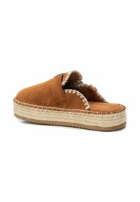 Sandalia de ante marrón tipo slide con suela de yute trenzado, que cuenta con una correa acolchada y detalles de costura en los bordes.