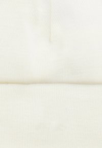 Berretto lavorato a maglia bianco con una texture a coste e un risvolto. Materiale morbido con una finitura liscia. Design semplice e privo di decorazioni.