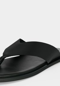 Μαύρο δερμάτινο σανδάλι με φαρδιά λουρίδα και μαξιλαρωμένη σόλα σε ανοιχτό φόντο.