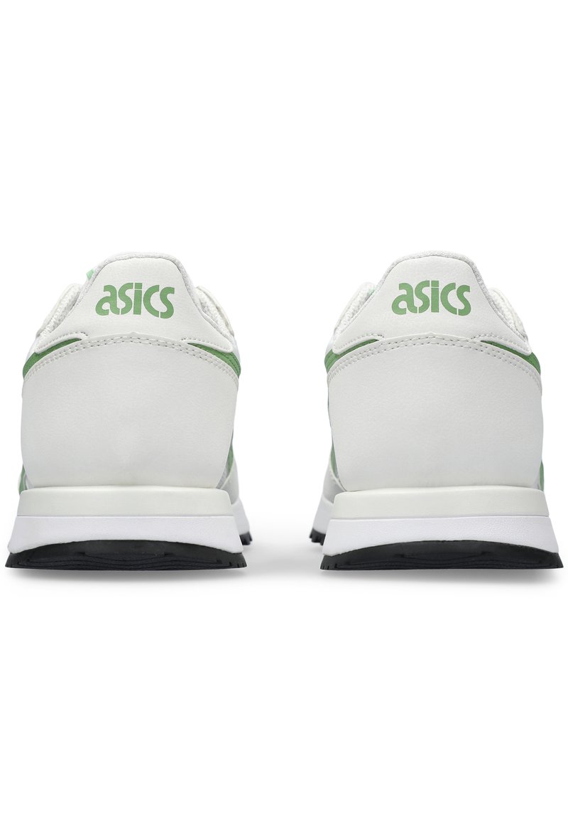 Par de zapatillas Asics blancas con acentos verdes, vistas desde atrás, mostrando el logo de la marca en la lengüeta del talón y suelas negras.