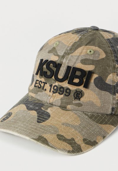 Καπέλο του μπέιζμπολ με καμουφλάζ σε χρώματα χακί, πράσινο και καφέ, με μαύρο κεντημένο λογότυπο «KSUBI EST. 1999» στο μπροστινό μέρος.