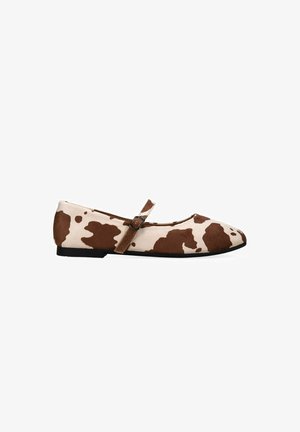 Zapato Mary Jane plano con un patrón de piel de vaca en marrón y beige y una pequeña correa con hebilla, mostrado contra un fondo blanco.