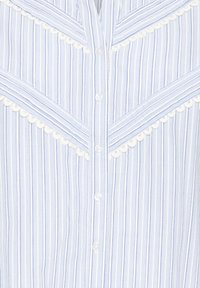 Camisa de rayas azul claro y blanca con ribete blanco ondulado, costuras verticales y diagonales, y cierre frontal con botones.