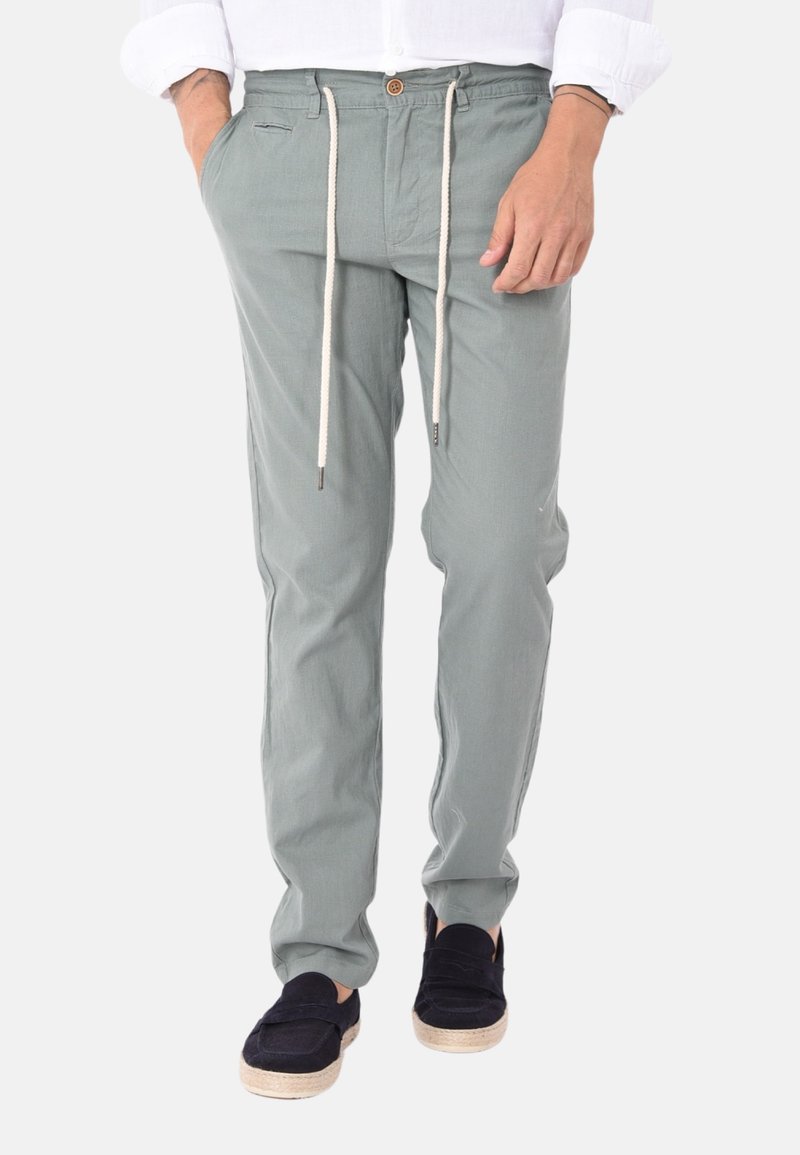 Pantaloni in cotone verde chiaro con vita elastica, chiusura con cordino, tasche laterali e un singolo bottone frontale.