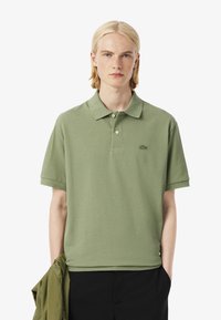 Polo shirt verde chiaro realizzato in cotone, con colletto classico, maniche corte e un piccolo logo ricamato sul petto.