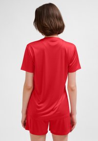Rotes Sportshirt aus leichtem Stoff, mit kurzen Ärmeln und legerer Passform. Glatte Textur mit minimalen Nähten für mehr Komfort.