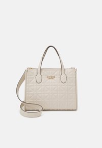 Beige gesteppte Handtasche mit zwei oberen Griffen und einem verstellbaren Schultergurt. Merkmale ein goldenes Logo und eine glatte Oberfläche mit angularm Muster.