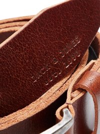 Bruine leren riem met een gestructureerde afwerking, voorzien van een zilveren metalen gesp en reliëfbranding details langs de band.