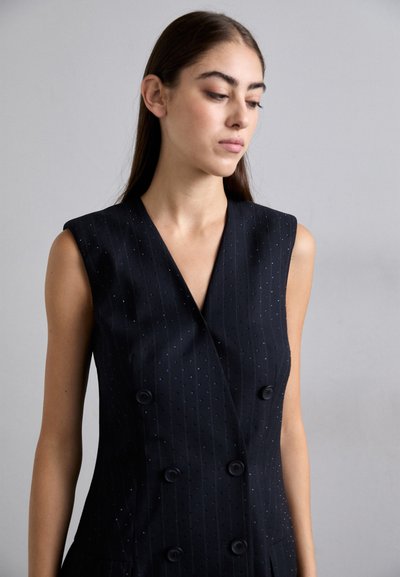 Rochie neagră, fără mâneci, cu decolteu adânc în V, față dublu-întărită, dungi verticale și mici accente albastre. Textură netedă și croială adaptată.