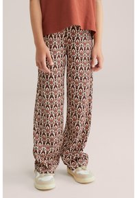 Platas kājas bikses krēmkrāsā ar ziedu rakstu sarkanā un brūnā krāsā. Mīksta auduma ar brīvu piegriezumu un elastīgām aprocēm.