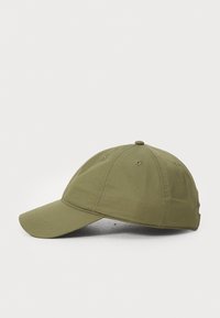 Grønn baseballcap laget av teksturert stoff. Har en buet skygge og seks-panel design med ventilasjonshull og en sydd toppknapp.