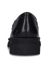 Mocassino in pelle nera con suola spessa, mostrato dal tacco, che mette in evidenza la parte superiore liscia e la suola spessa e lavorata, su sfondo bianco.