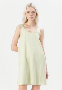 Vestido de gingham verde claro com decote quadrado e alças largas. O tecido parece suave, com um corte descontraído, adequado para o uso casual.
