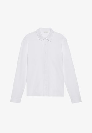 Chemise blanche à manches longues avec un col pointu, fermeture à boutons sur le devant et poignets arrondis, présentant une texture de tissu lisse et douce.