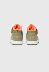 Olivengrønne sneakers med lys orange fluffy foring, hvide såler og "KangaROOS" logo broderet på hælen, vendt bagud.