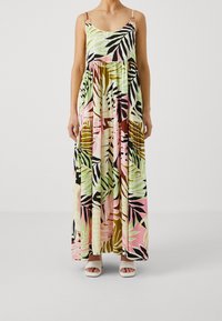 Maxikleid mit einem bunten Blattmuster in Grün, Rosa und Schwarz, mit Spaghettiträgern und lockerer Passform. Akzentuiert mit runden Beschlägen.