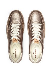 Zapatillas de cuero bronce con cordones blancos, puntera redondeada y plantilla color crema. Logo de Pikolinos en una etiqueta de cuero tostado. Textura suave con costuras detalladas.