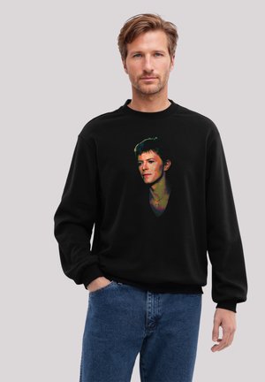 Schwarzer Kapuzenpullover mit grafischem Design eines Gesichts und bunten Akzenten. Klassische Passform mit geripptem Halsausschnitt und Bündchen.