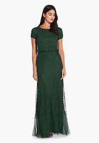 Robe de soirée verte ornée avec un corsage ajusté et une longue jupe fluide. Comprend des broderies détaillées et un superposé en tulle. Manches courtes.