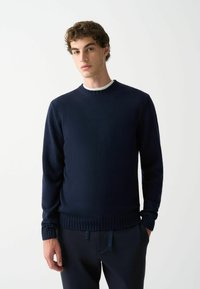Dunkelblauer Pullover aus glattem Strickstoff, mit einem gerippten Rundhalsausschnitt und Bündchen. Das Design ist schlicht und tailliert mit einem geraden Saum.