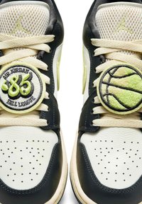 Czarne skórzane sneakersy z kremową siateczką i sznurowadłami. Ozdobione naszywkami: jedną okrągłą z napisem "86" oraz drugą przypominającą koszykówkę.