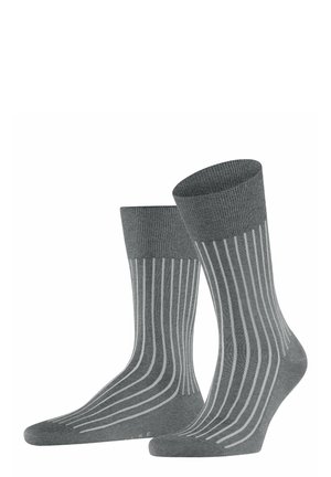 Chaussettes grises avec une texture côtelée, présentant des rayures verticales gris clair, un revers structuré et une zone de orteil lisse.