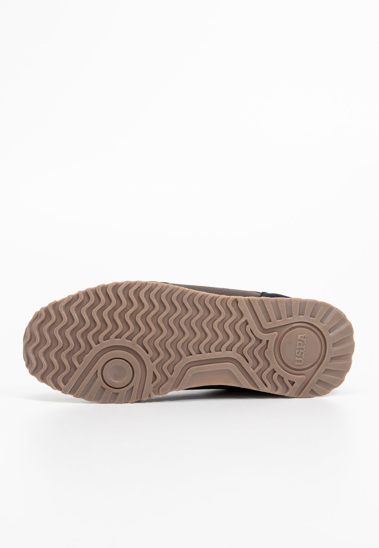 Suola in gomma marrone con motivo a zigzag, caratterizzata da accenti circolari e branding. Progettata per la trazione e la durata.