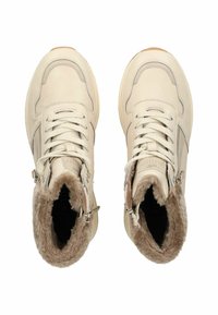 Béžové kožené tenisky s podšívkou z umělé kožešiny, tkaničkami a zipy. Mají gumovou podrážku a dekorativní prošívání podél okrajů.