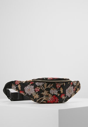 Banane en tissu noir avec une broderie florale complexe en rouge, or et violet ; elle possède un zip sur le dessus et une sangle réglable.