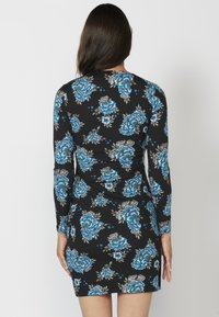 Schwarzes langärmliges Kleid mit blauem Blumenmuster und figurbetontem Schnitt. Hergestellt aus einem dehnbaren Stoff mit glatter Textur.