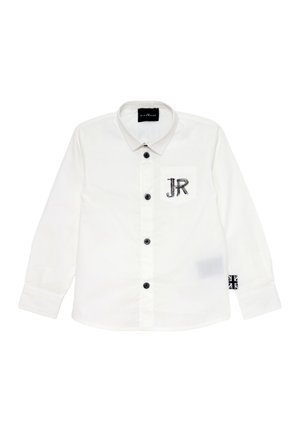 Camicia bianca a maniche lunghe con colletto, bottoni neri, tasca con ricamo "JR" e una decorazione a forma di bandiera sul manica.