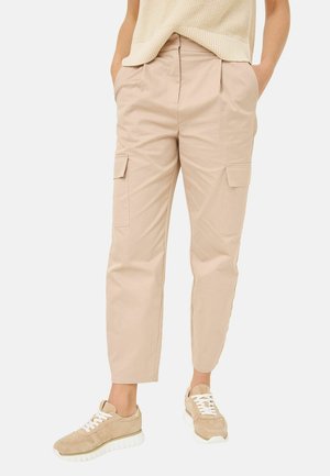 Beige cargobroek met zijzakken, relaxte pasvorm, plooien bij de taille, cropped lengte, gecombineerd met lichtgekleurde sneakers. Gestructureerde stof.