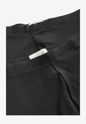 Czarne legginsy ciążowe wykonane z miękkiej, elastycznej bawełny. Posiadają gładki pas z metką "NEXT maternity".