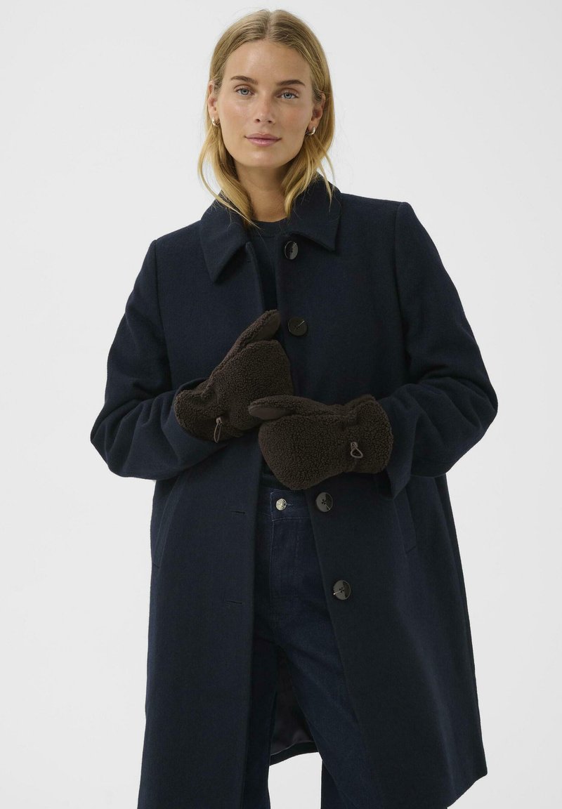 Vlnený kabát v tmavomodrej farbe s výstrihom a piatimi gombíkmi. Hnedé fleecové rukavice so otvorom na palec, mäkká textúra.