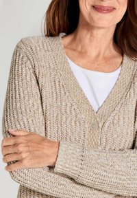 Lichtbeige gebreide cardigan met een V-hals, voorzien van een enkele knoopsluiting en geribde manchetten, die een gestructureerde, gezellige stof laat zien.