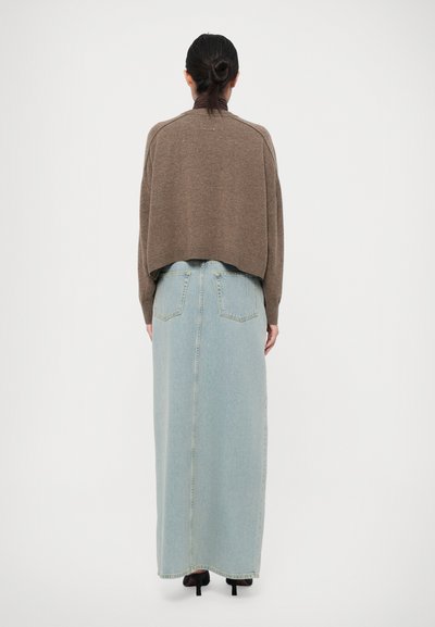 Brown cropped sweater with raglan sleeves paired with a light blue denim maxi skirt featuring back pockets and a straight silhouette.