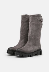 Botas altas hasta la rodilla de ante gris con un acabado texturizado, suela gruesa de goma negra y detalle de hebilla lateral.