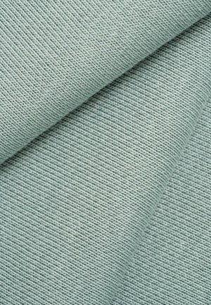 Close-up of folded light blue fabric showing fine ribbed knit texture and diagonal folding lines.