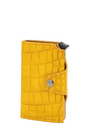 Cartera de cuero texturizado amarilla con cierre de botón a presión y una tarjeta o dispositivo negro parcialmente visible en su interior.