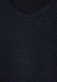 Tmavě námořnická ribbovaná látka s jemným texturovaným povrchem a klasickým designem ve tvaru V. Nebyly přítomny žádné výrazné kovové prvky ani další akcenty.